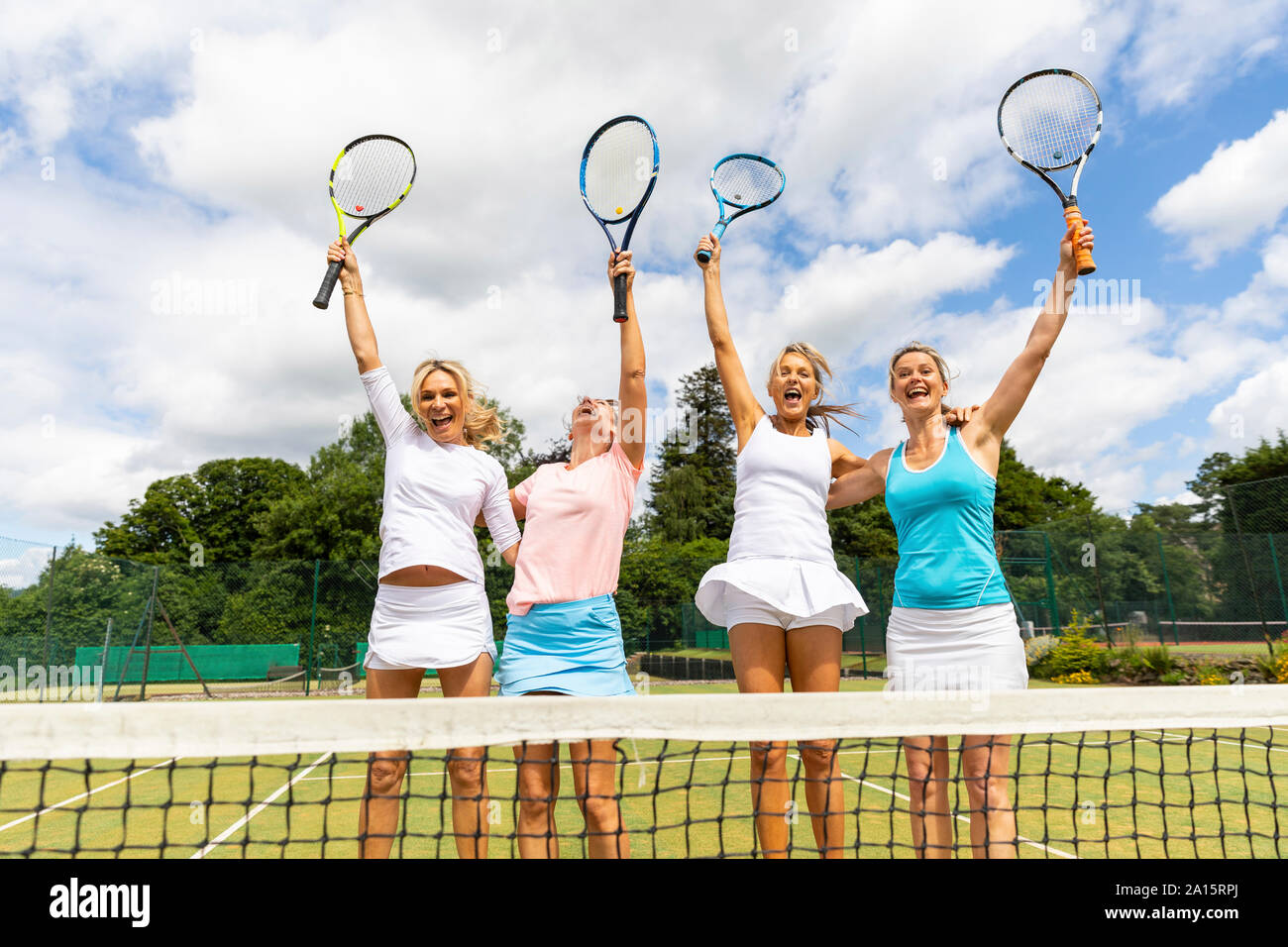 Happy female tennis players celebrating the victory on grass court ...