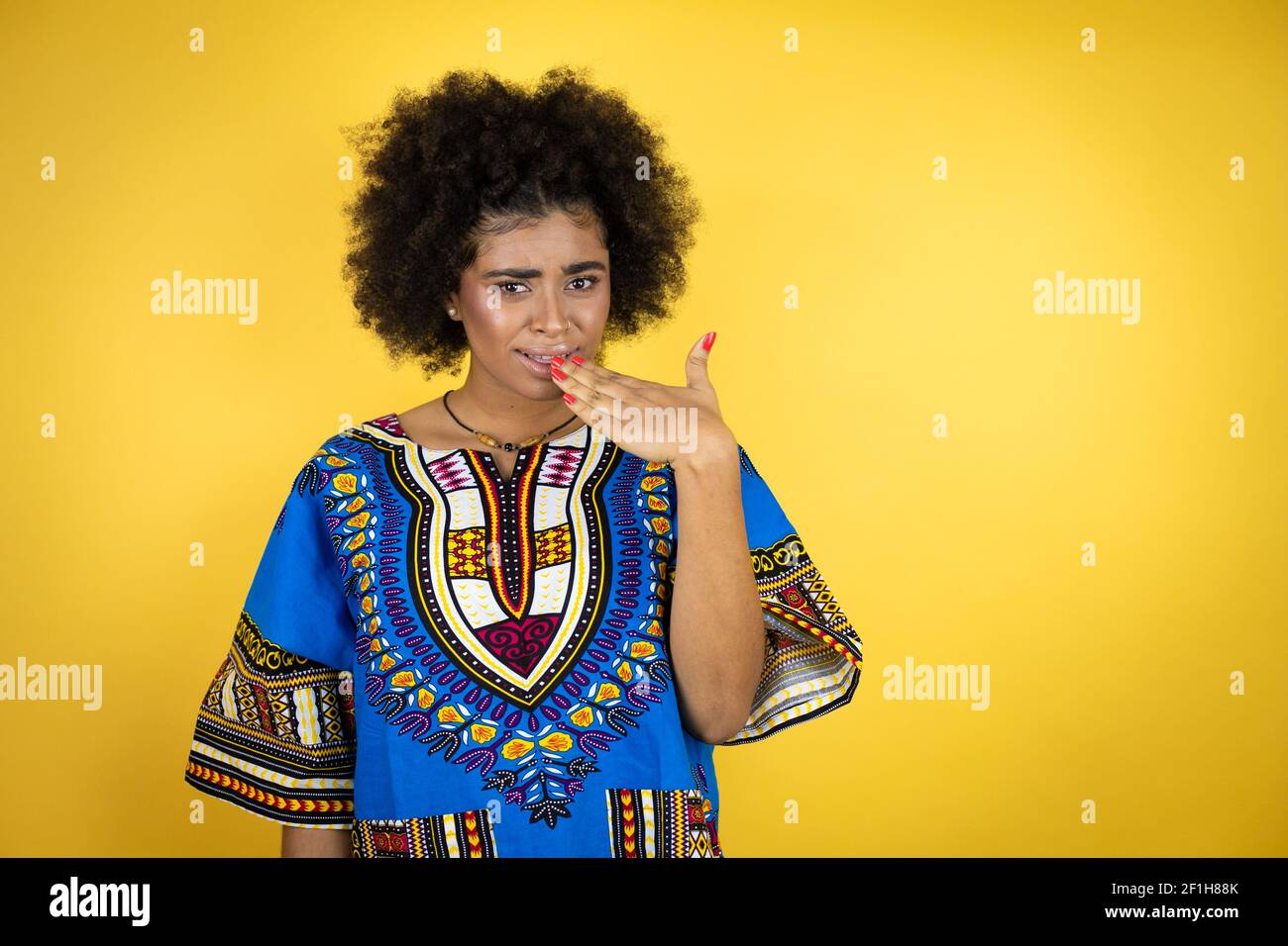 African American Woman Wearing African Clothing Over Yellow Background Disgusted With Her Hand 