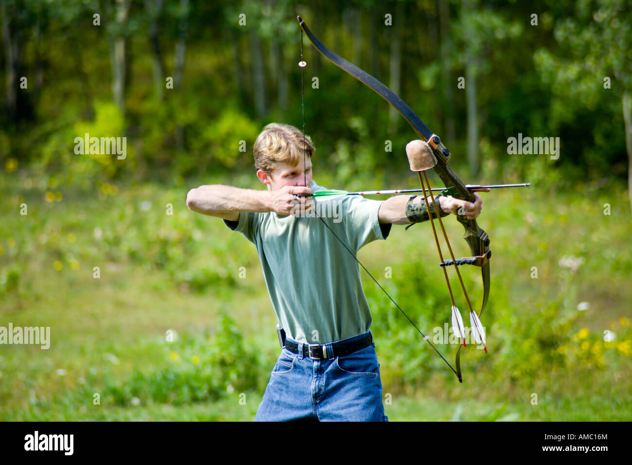 A Young Man 20 S Shooting Archery Using A Traditional Bow And Arrow Recurve And Feathers Stock 9024