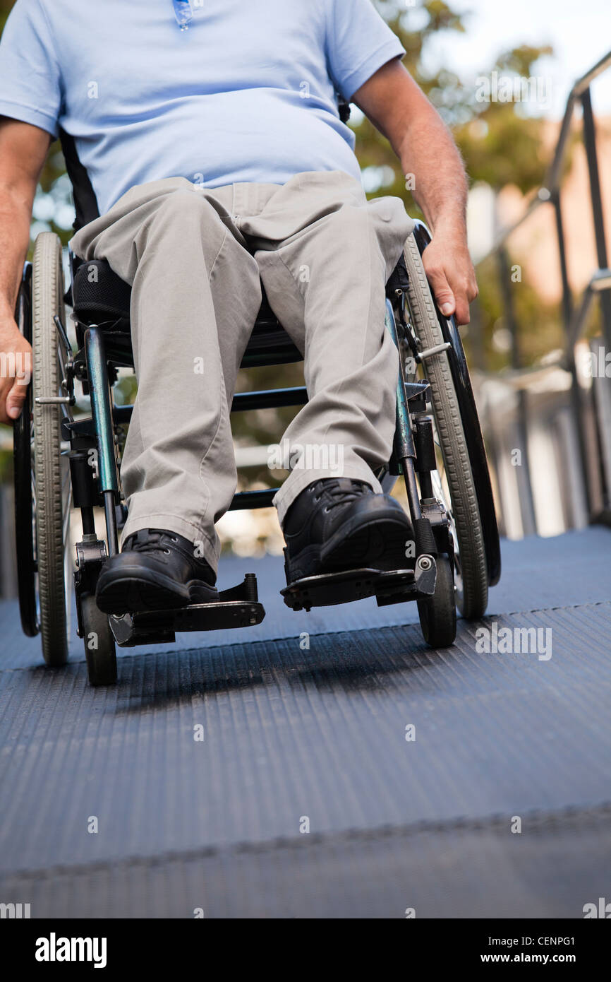 Man with spinal cord injury in wheelchair moving up an outdoor