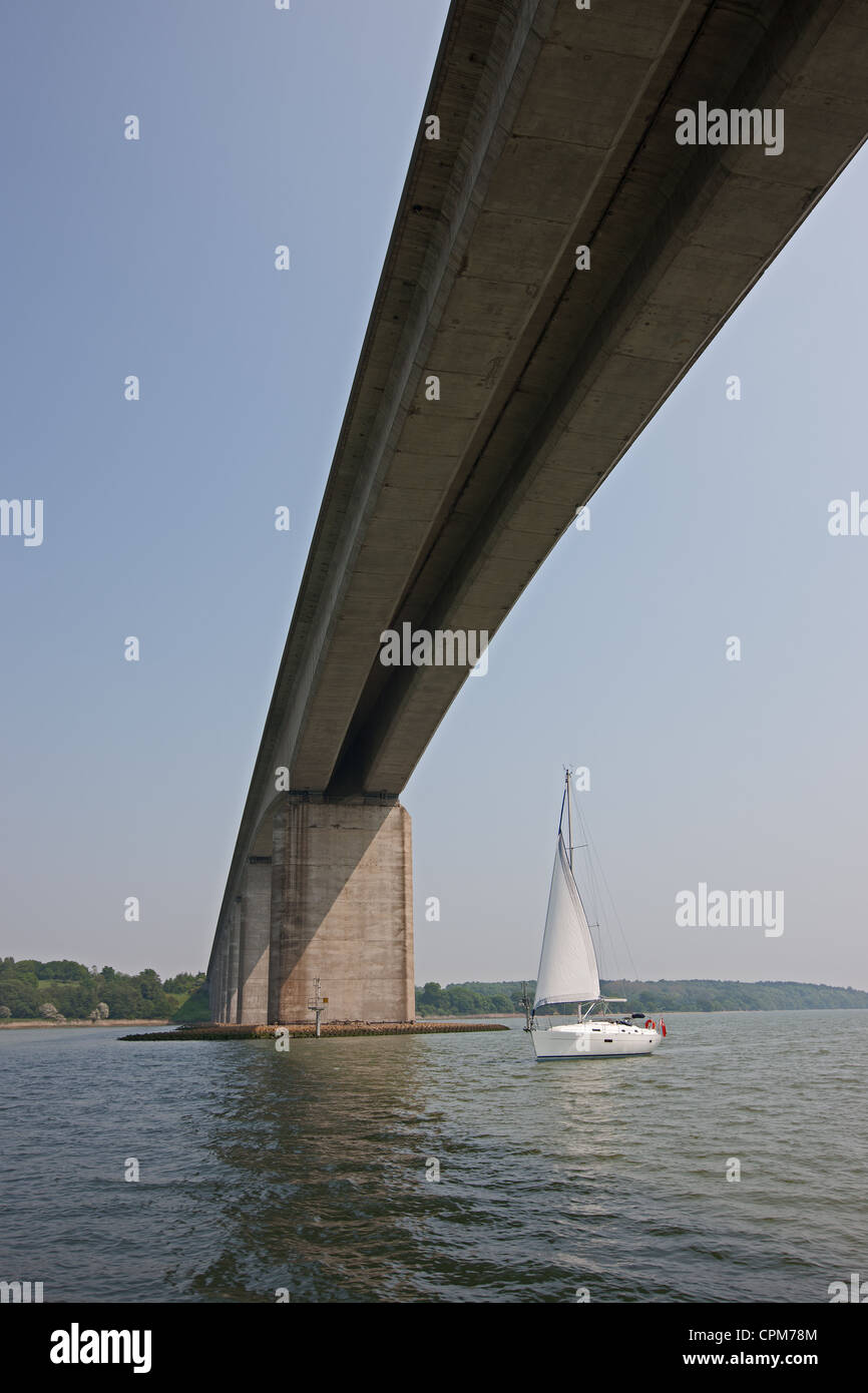 yacht speeds under bridge