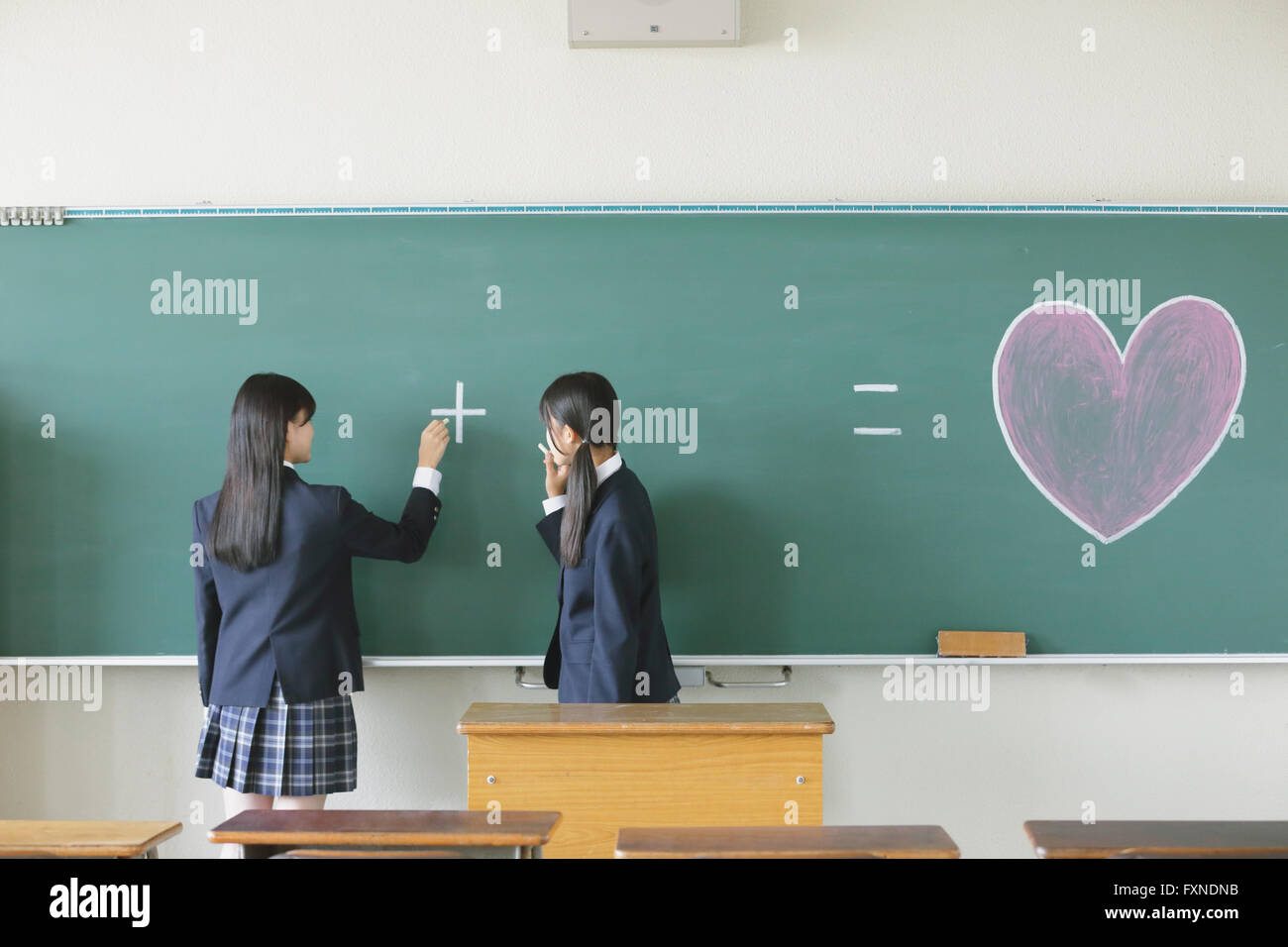 Japanese highschool students in front of classroom blackboard Stock