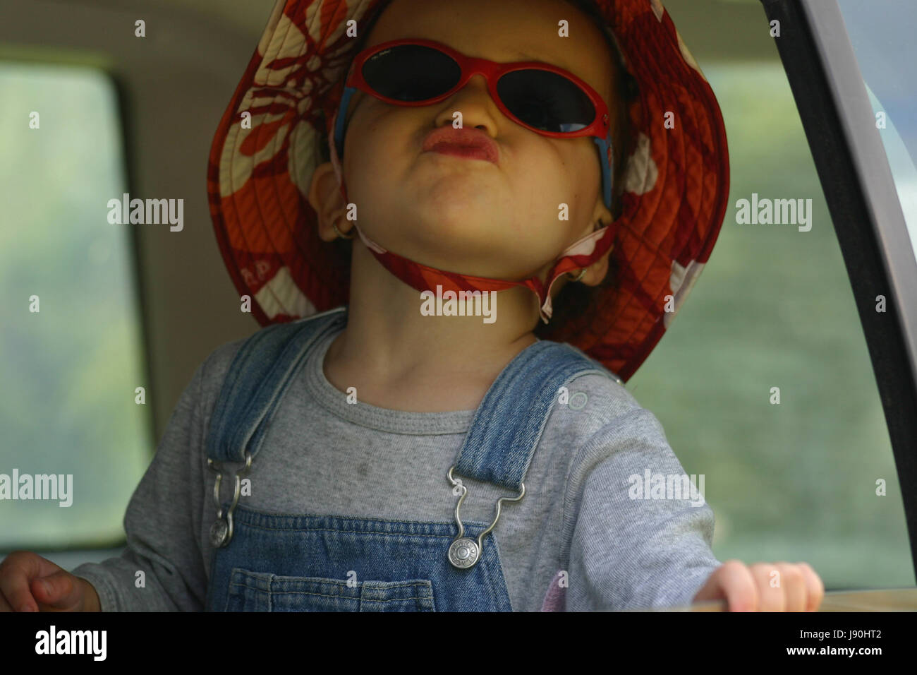 Cute little girl saying goodbye from car window Stock Photo Alamy