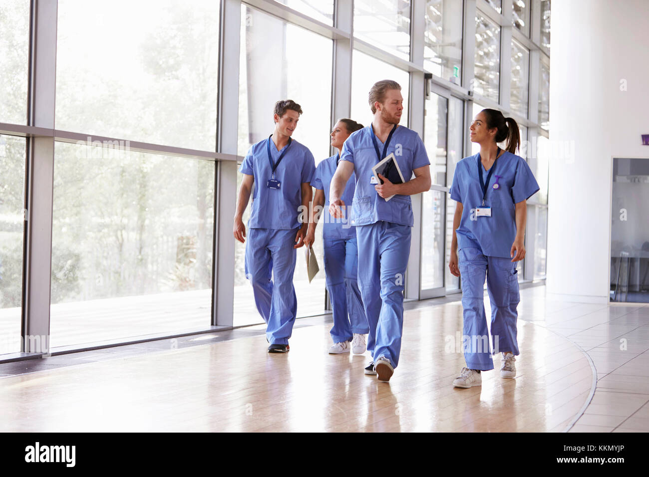 Four Healthcare Workers In Scrubs Walking In Corridor Stock Photo Alamy